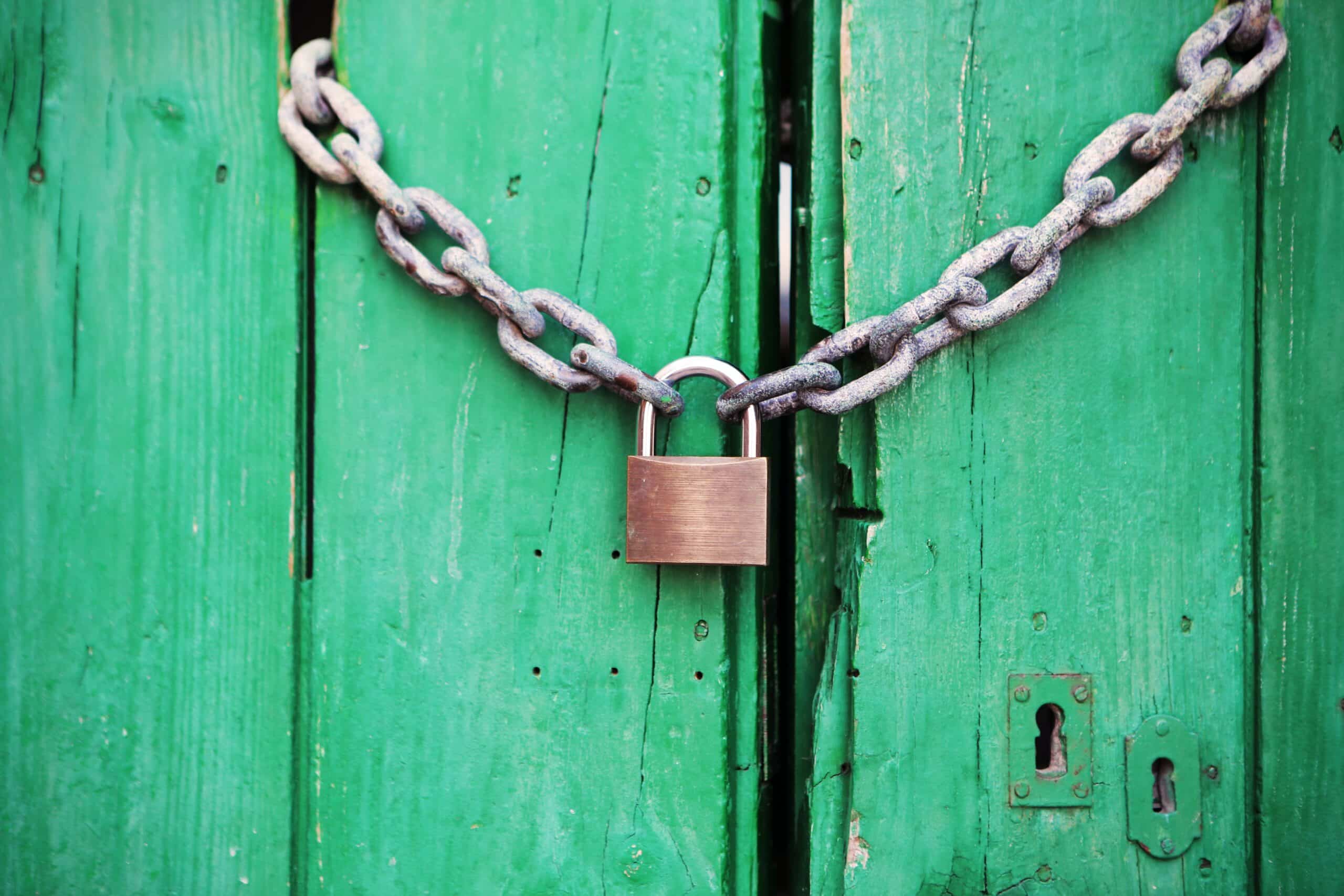 serratura con catena su porta in legno verde